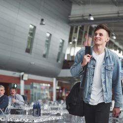 Young handsome man with a bag on his shoulder in a hurry to the airport